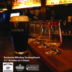 A perfect pour pint of guinness in front of a tasting flight with 4 whiskey glasses on a bar counter