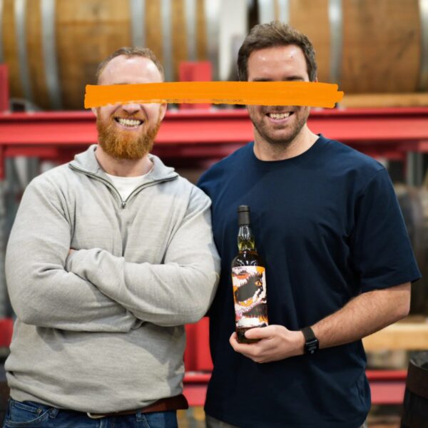 Reacted whiskey, Michael Cowman and Ronan Collins holding a bottle of whiskey